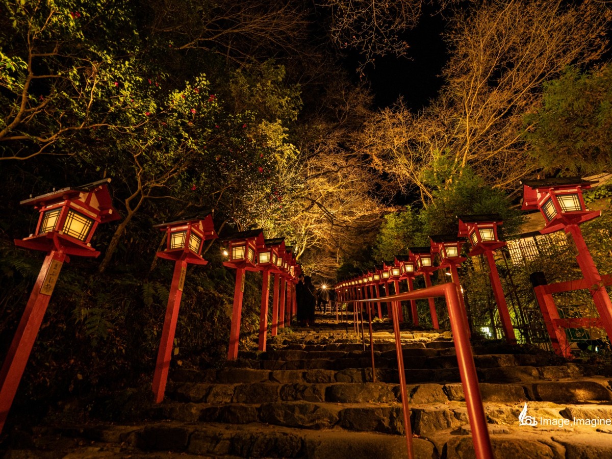 夜にライトアップされた貴船神社の本殿に繋がる階段を足元から上空にかけて撮影した写真。